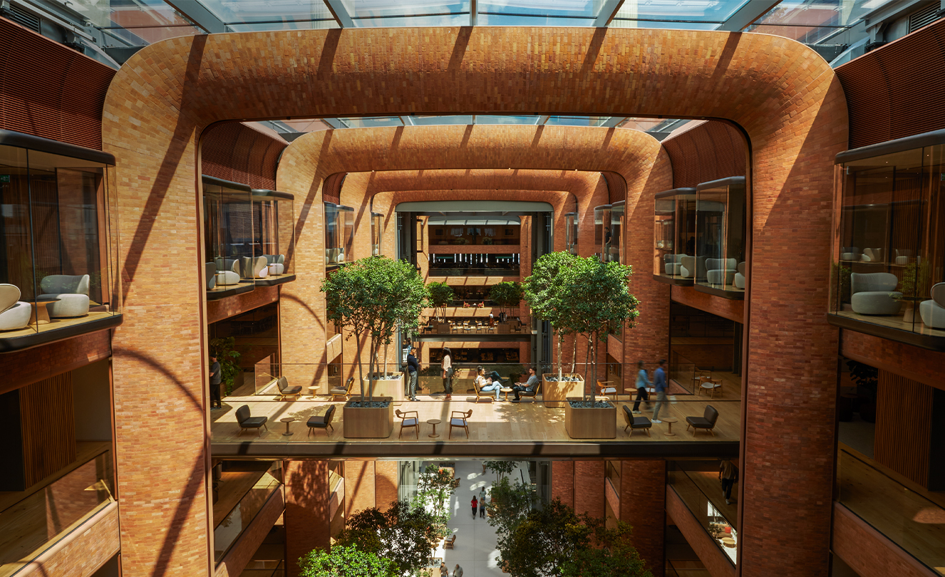 The five-storey Battersea atrium with the sun streaming in through the glass roof, lighting team members below.