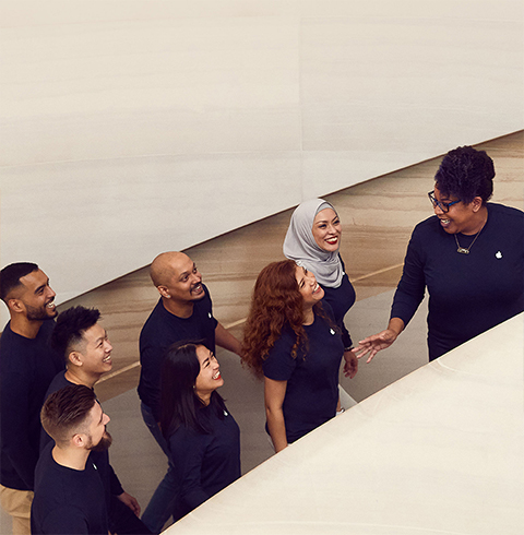 幾位團隊成員在 Apple Store 內上樓梯。