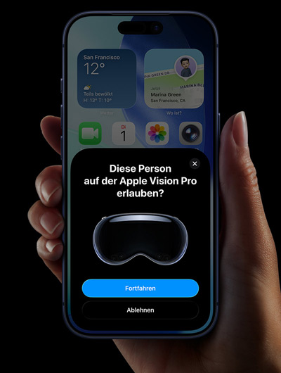Eine Hand hält ein iPhone; das iPhone Display zeigt ein Fenster mit der Meldung „Diese Person auf der Apple Vision Pro erlauben“ und den Schaltflächen „Fortfahren“ und „Ablehnen“