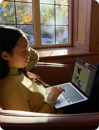 A person sitting in a chair using their MacBook Air