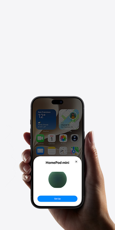 一隻手拿著 iPhone，螢幕顯示的家居 app 中，有智能家居配件設定提示