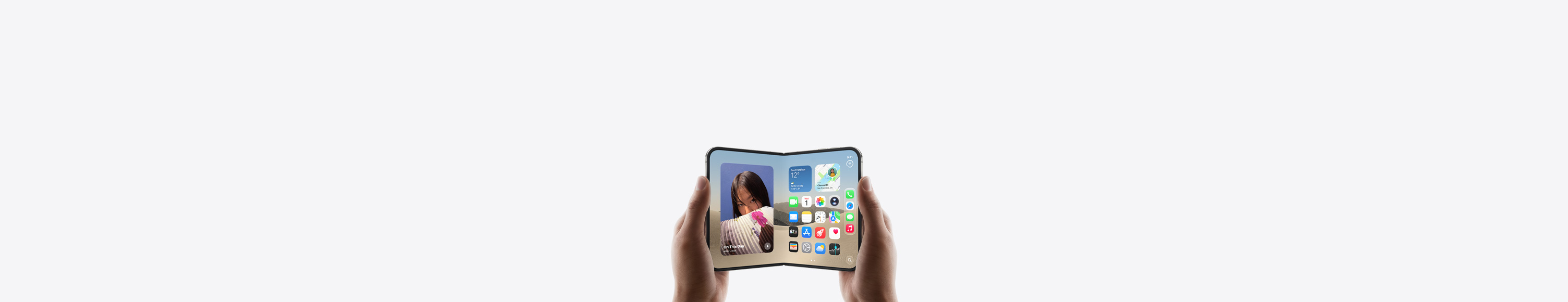 iPhone Duo, held by two hands in landscape orientation, unfolded, interior display features Home Screen