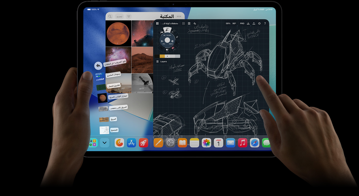 جهاز iPad Pro، الجزء الأمامي الخارجي، الوضع الأفقي، يد يمنى تشير إلى ملفات مجلد التنزيلات على شكل مروحة، الشاشة تعرض واجهة iPadOS 26 مع تطبيقات متعددة مفتوحة تشمل تطبيقاً لتعديل الصور مع مخططات مفصلة لروبوت وتعليقات توضيحية مكتوبة بخط اليد ومراحل تصميم متعددة، ومكتبة الصور