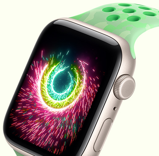 Apple Watch SE 3, screen shows Activity rings sparking like fireworks, aluminium case, starlight colour, connected to Nike Sport Band, green spark colour (mint green, subtle pattern of grey shapes, circular perforations)
