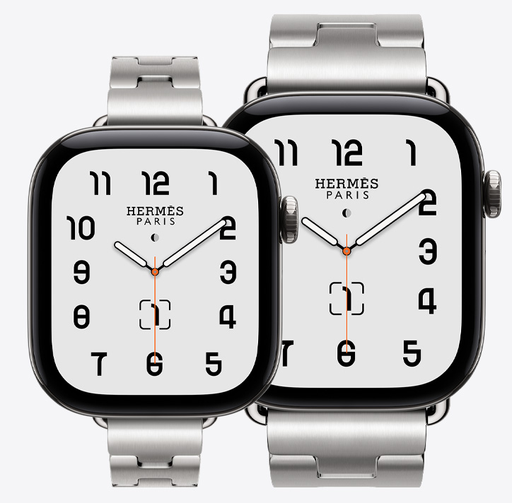 Apple Watch Hermès Series 12, both 42mm and 46mm models shown, Classic analogue watch face (hour, minute and second hands, complications: lunar phase, date), titanium case, silver colour, 42mm paired with Grand H Fin strap, satiné colour, 46mm paired with Grand H strap, satiné colour