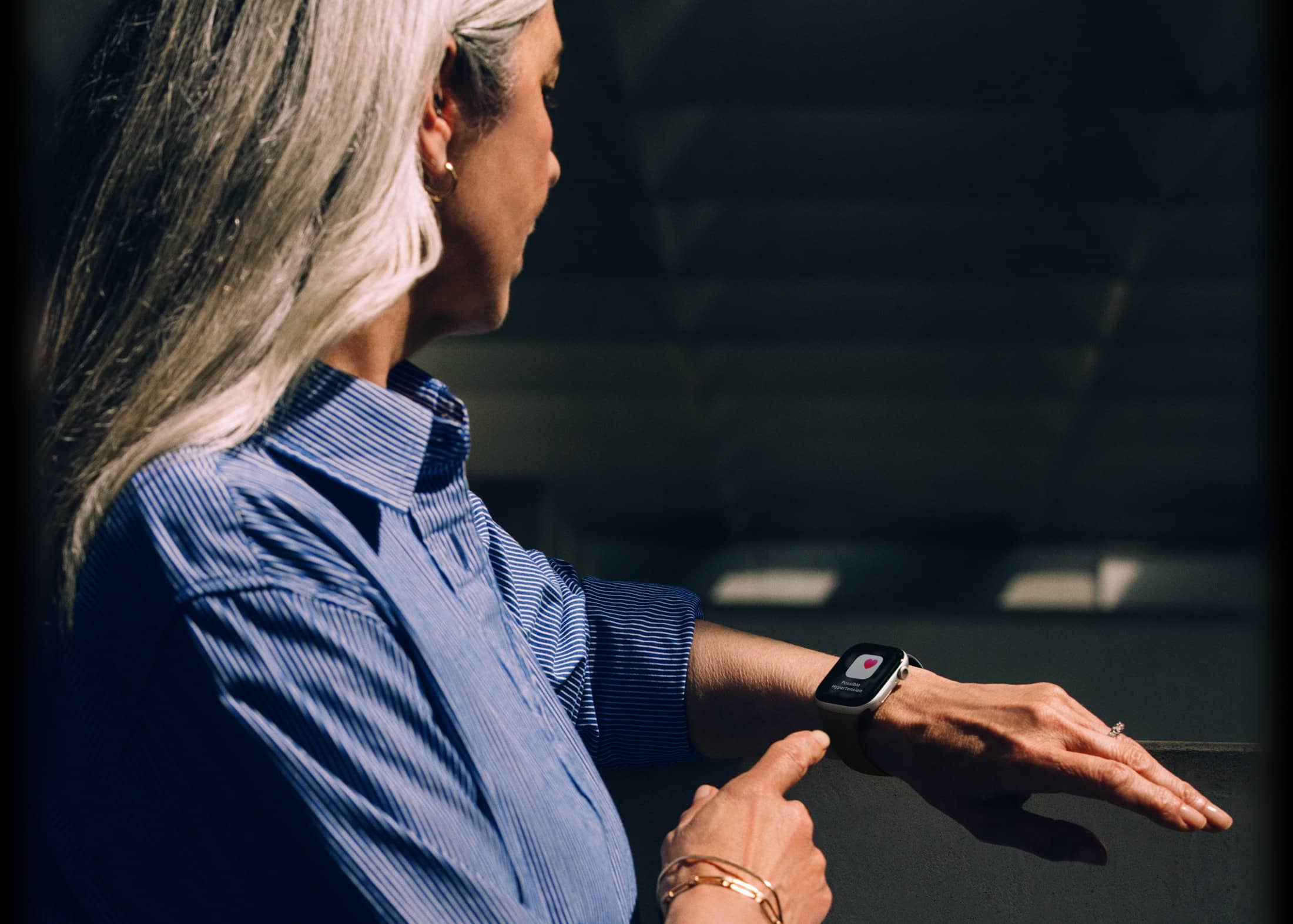 Човек чете известие за хипертония на своя Apple Watch Series 11