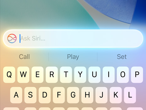 A close‑up of a cursor making a Siri request on macOS Tahoe.