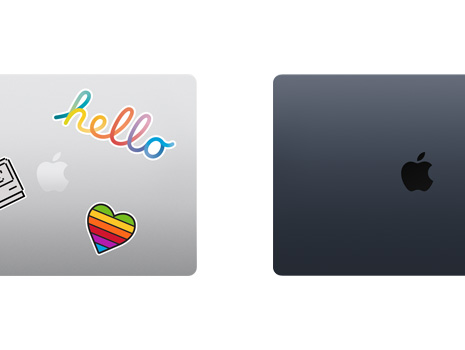 A top-down view of two closed Mac laptops, one with stickers.