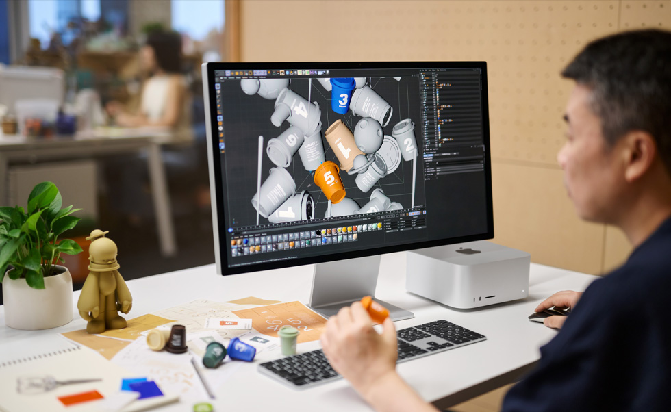 En designer bruger Mac til 3D-rendering.