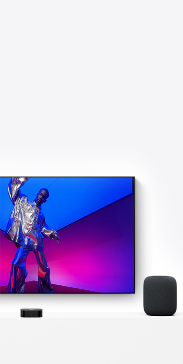Apple TV 4K et HomePod, couleur minuit, l’écran de la TV montre une personne portant une tenue argent métallique