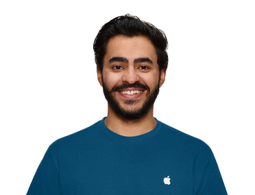 Un Spécialiste Apple Store souriant, vêtu d’un t-shirt Apple bleu