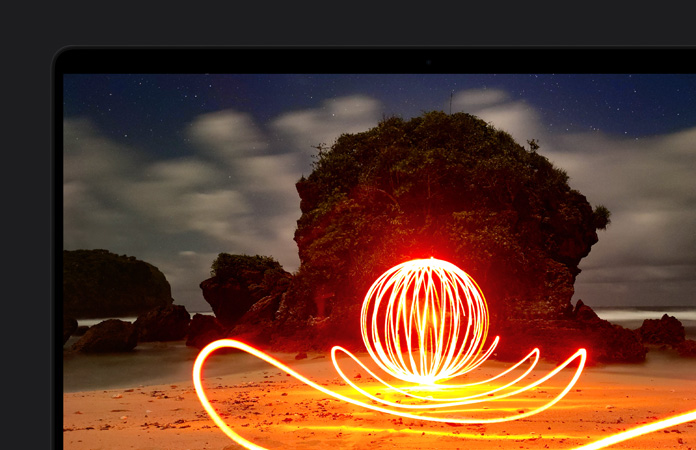 En un MacBook Pro, la imagen de una instalación de arte muy brillante en una playa destaca el contraste de la pantalla gracias al rango dinámico extremo