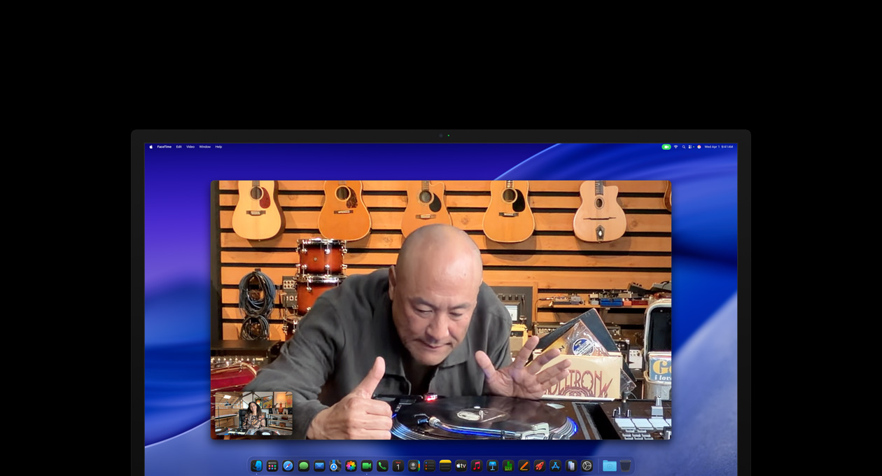 Two people on a video call on Studio Display XDR, Center Stage keeps them centered in the frame even as one person in a music shop moves to take a closer look at a turntable